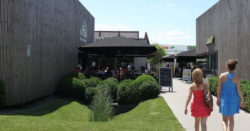 L'arrivée dans le pôle restaurant au centre est marqué par l'architecture bois et une végétation soignée