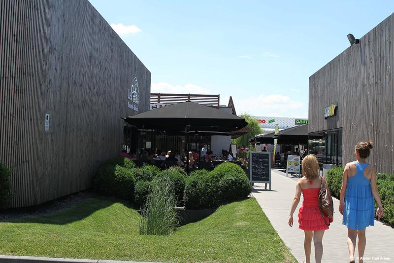 L'arrivée dans le pôle restaurant au centre est marqué par l'architecture bois et une végétation soignée