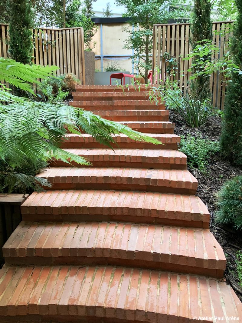 Un escalier de brique qui reconnecte deux niveaux du jardin